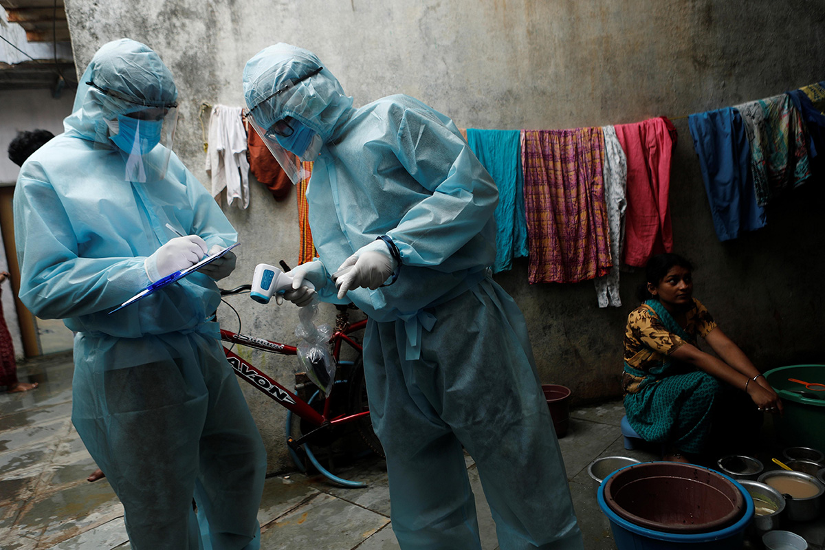 Healthcare workers write down details of residents in a slum during a check-up camp for the Coronavirus disease (COVID-19) in Mumbai, on 17 June 2020.