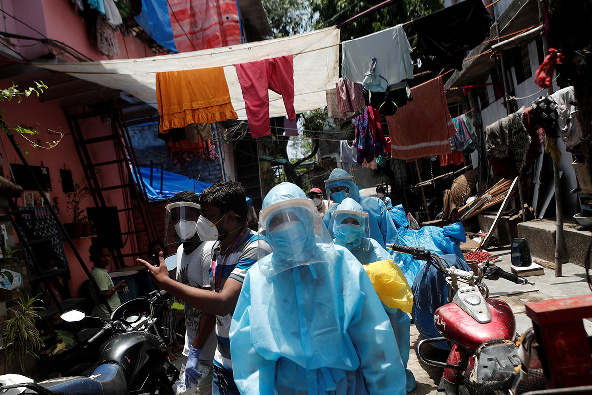 Healthcare workers wearing personal protective equipment (PPE) and volunteers walk through a slum in Dharavi, one of Asia's largest slums, to check residents during a lockdown to slow the spread of the coronavirus disease (COVID-19), in Mumbai, India, on 7 June 2020.