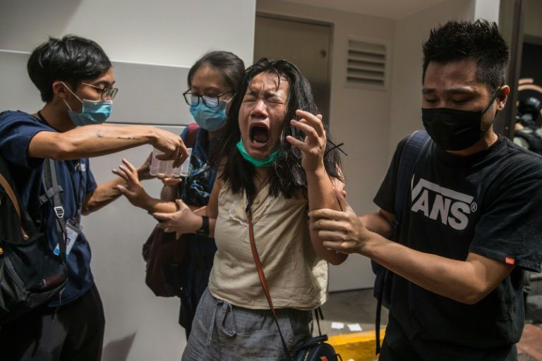 A woman reacts after being hit by pepper spray as police tried to stop protests in Hong Kong.