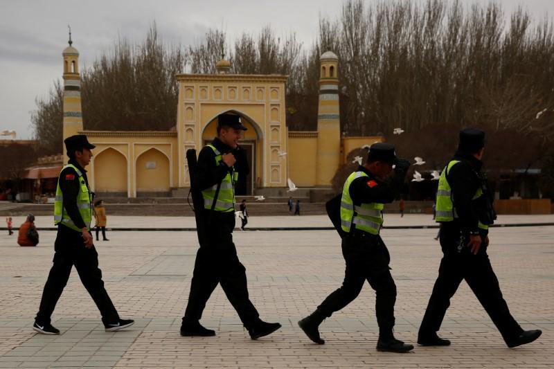 A police patrol walk in front of the Id Kah Mosque in the old city of Kashgar, Xinjiang Uyghur Autonomous Region, China, on 22 March 2017.