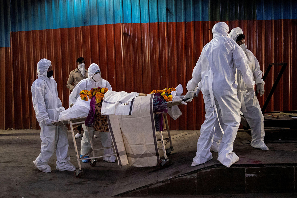 Health workers pull a stretcher with the body of a woman, who died due to the coronavirus disease (COVID-19), at a crematorium in New Delhi, India, on 3 October 2020.