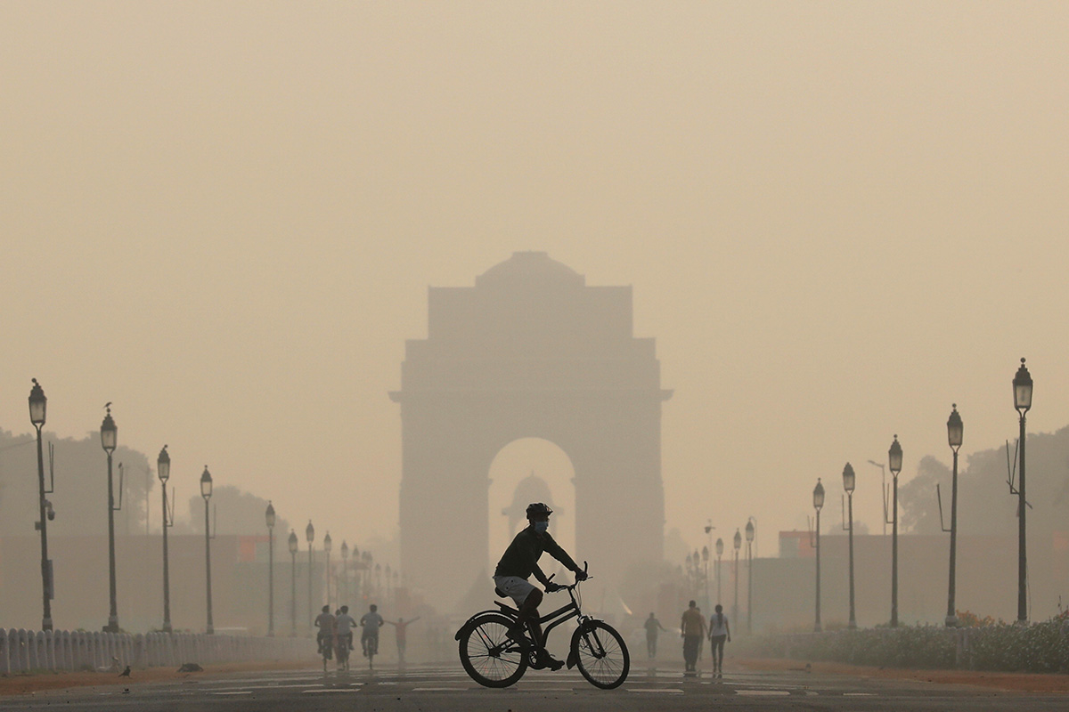 A man rides a bicycle on a smoggy morning near India Gate in New Delhi, on 17 October 2019.