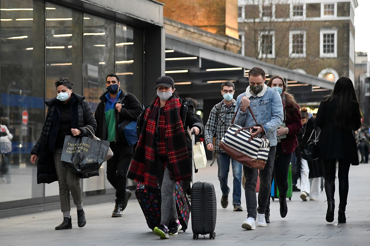 Travellers walk outside of King's Cross station as the British government imposes a stricter tiered set of restrictions amid the coronavirus disease (COVID-19) pandemic, in London, Britain, on 20 December 2020.