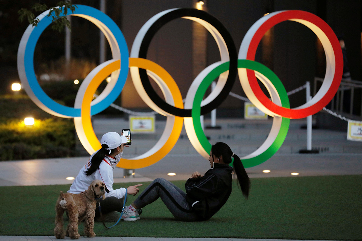 Women work out in front of the Olympic rings near the National Stadium in Tokyo, Japan, on 22 January 2021.