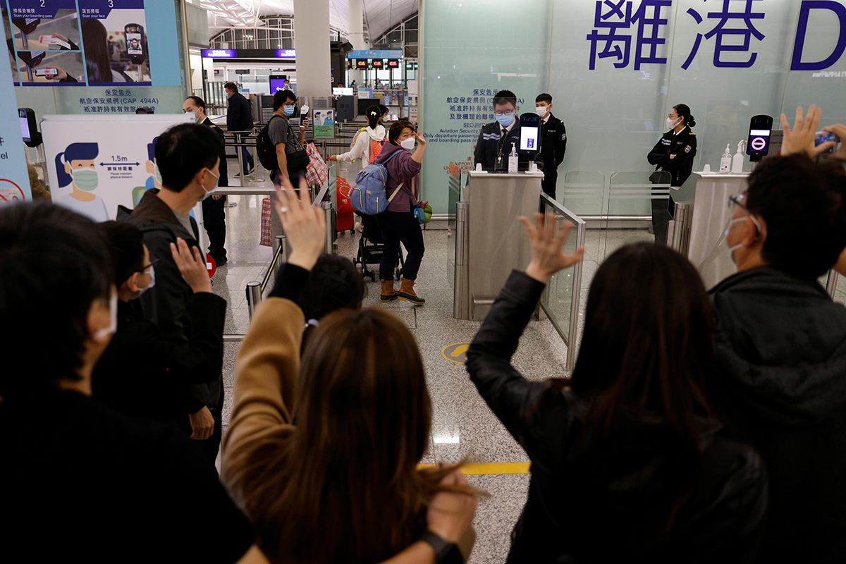 The Lai family, who are emigrating to Scotland, wave goodbye to their friends who are seeing them off before their departure at Hong Kong International Airport in Hong Kong, China, on 17 December 2020.