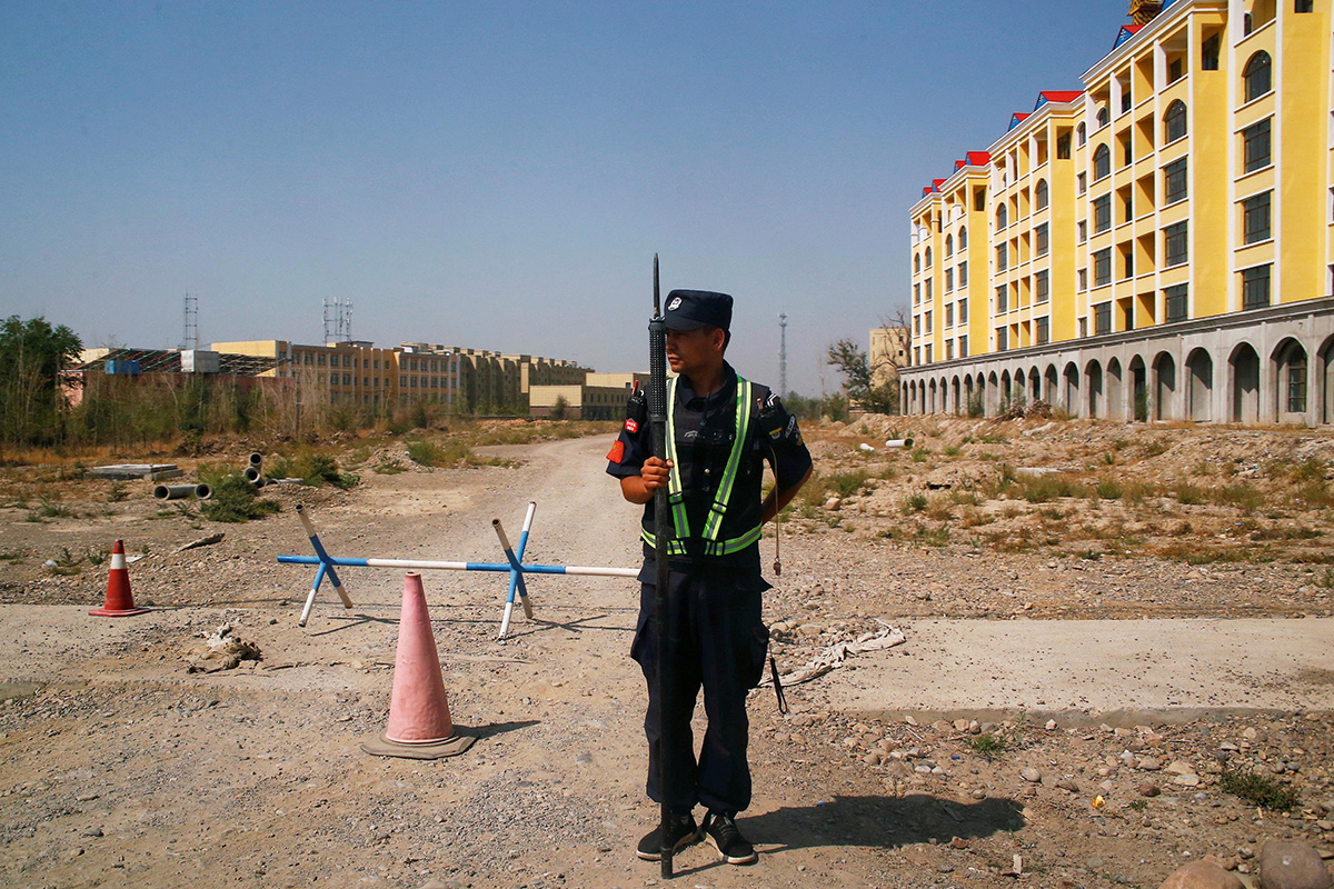 A Chinese police officer takes his position by the road near what is officially called a vocational education center in Yining in Xinjiang Uyghur Autonomous Region, China, on 4 September 2018.