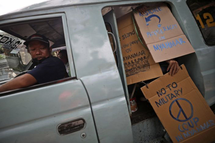 Activists display posters as they board a minivan during a protest against the ousting of the Myanmar's elected government and its leader Aung San Suu Kyi outside the Embassy of Myanmar in Jakarta, Indonesia, on 5 February 2021. Myanmar's military seized power shortly before a new session of Parliament was to convene on Monday and detained Suu Kyi and other top politicians.