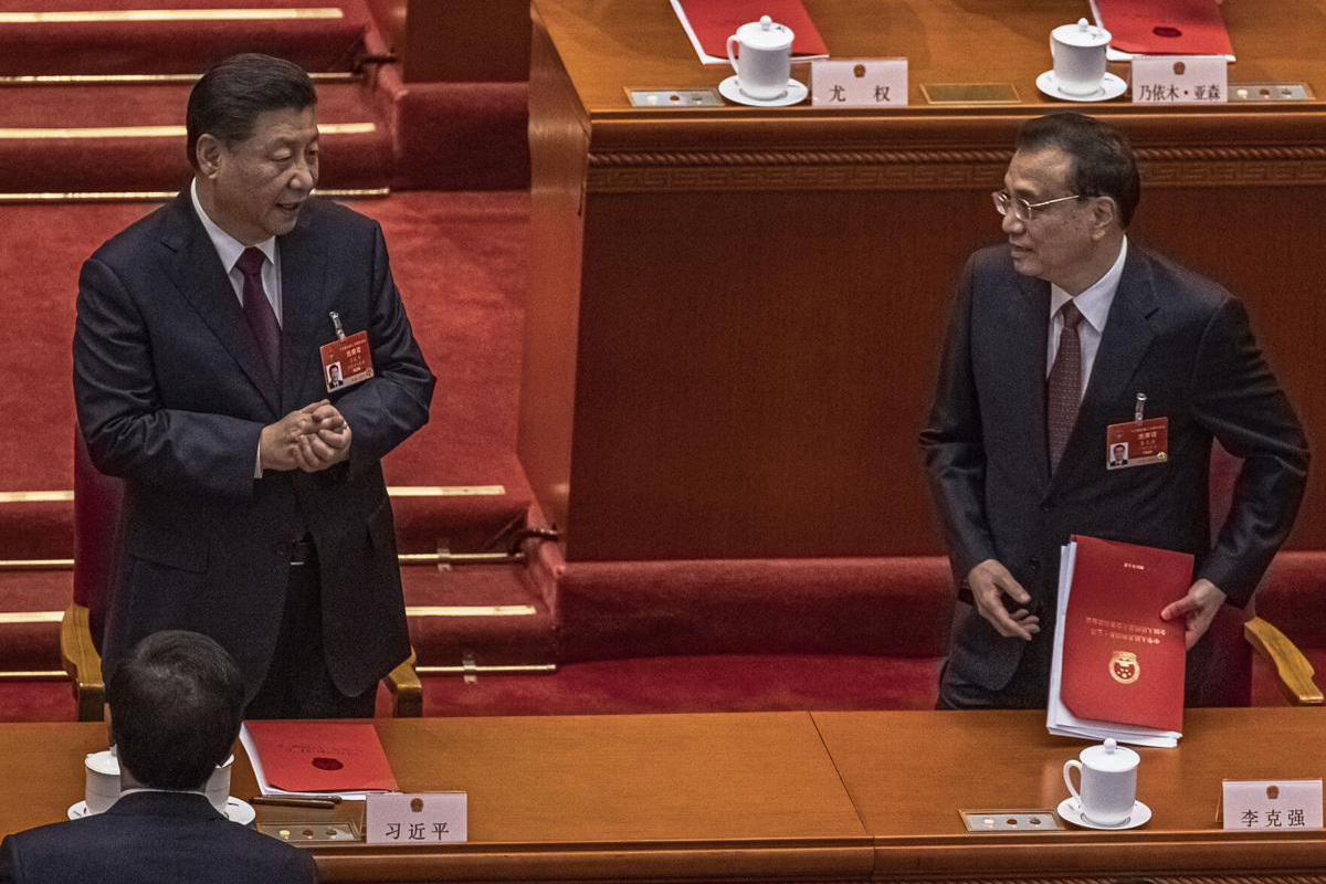 Chinese President Xi Jinping, left, and Premier Li Keqiang talk after the closing session of the National People's Congress (NPC), at the Great Hall of the People, in Beijing, on 11 March 2021. China’s ceremonial legislature has endorsed the ruling Communist Party’s latest move to tighten control over Hong Kong by reducing the role of its public in picking the territory’s leaders.