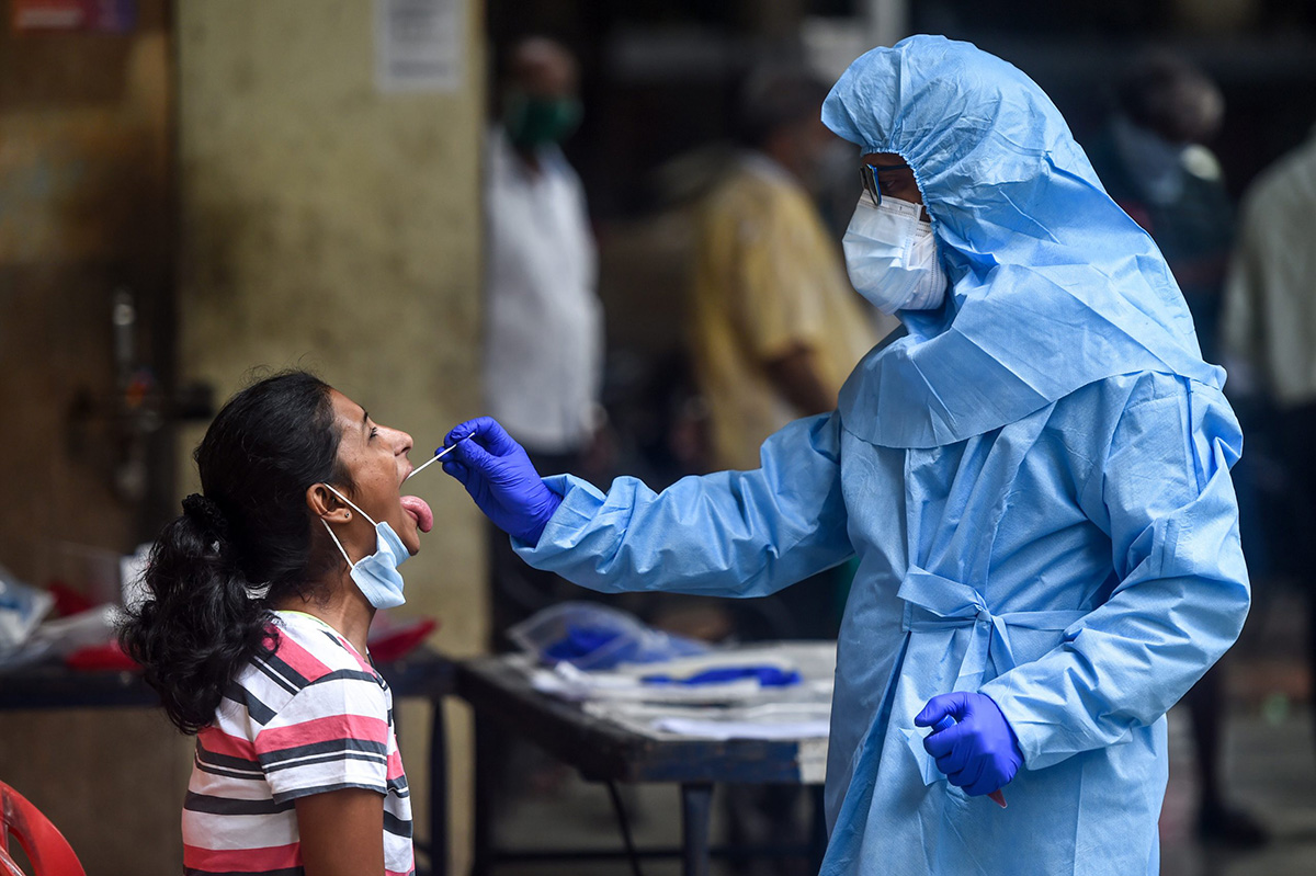 A health worker takes a swab sample from a resident getting tested for the COVID-19 coronavirus near residential buildings in Mumbai on 16 July 2020.