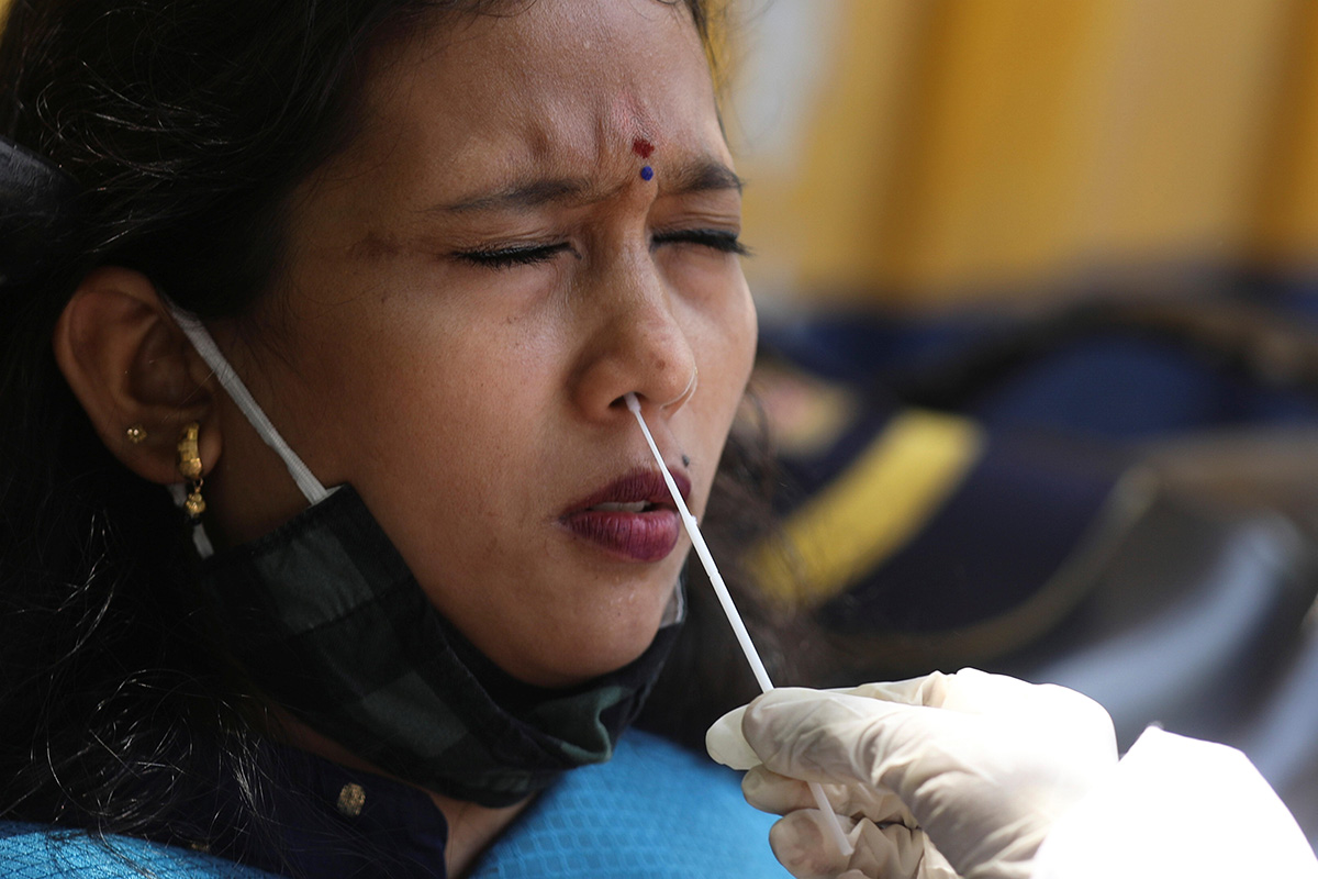 A health worker collects a swab sample from a woman during a rapid antigen testing campaign for the coronavirus disease (COVID-19), on a street in Mumbai, India, on 30 March 2021.