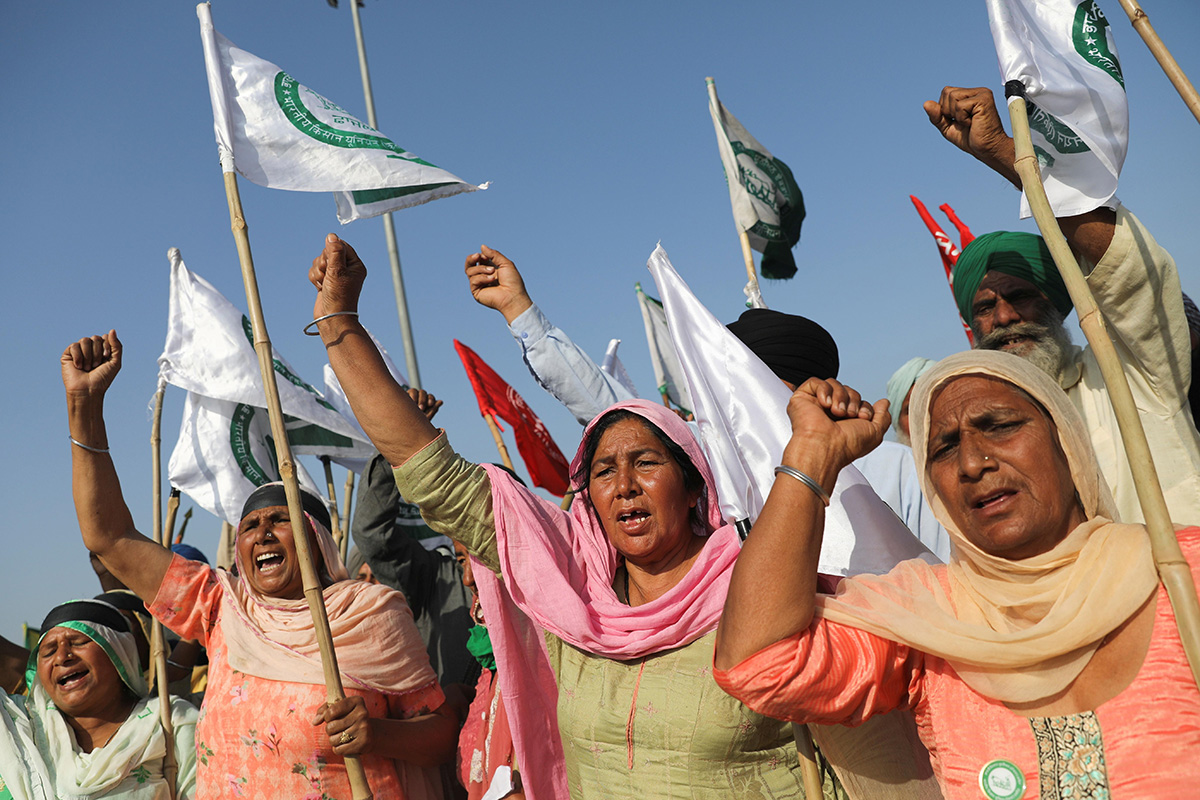 Women shout slogans at an expressway which was blocked by farmers to mark the 100th day of the protest against the farm laws, near Kundli border, in Haryana, India, ono 6 March 2021.