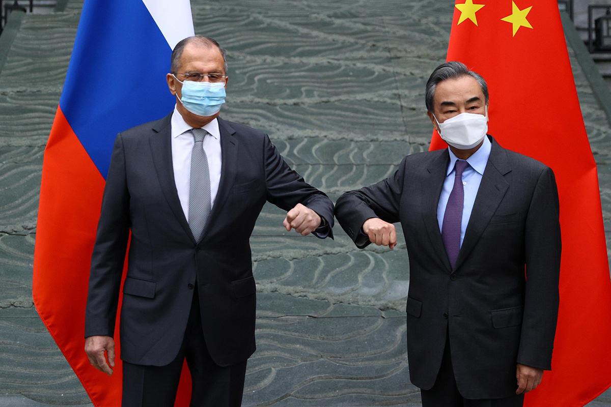 Russia's Foreign Minister Sergei Lavrov and China's State Councilor and Foreign Minister Wang Yi wearing protective face masks pose for a picture during a meeting in Guilin, China, on 22 March 2021.