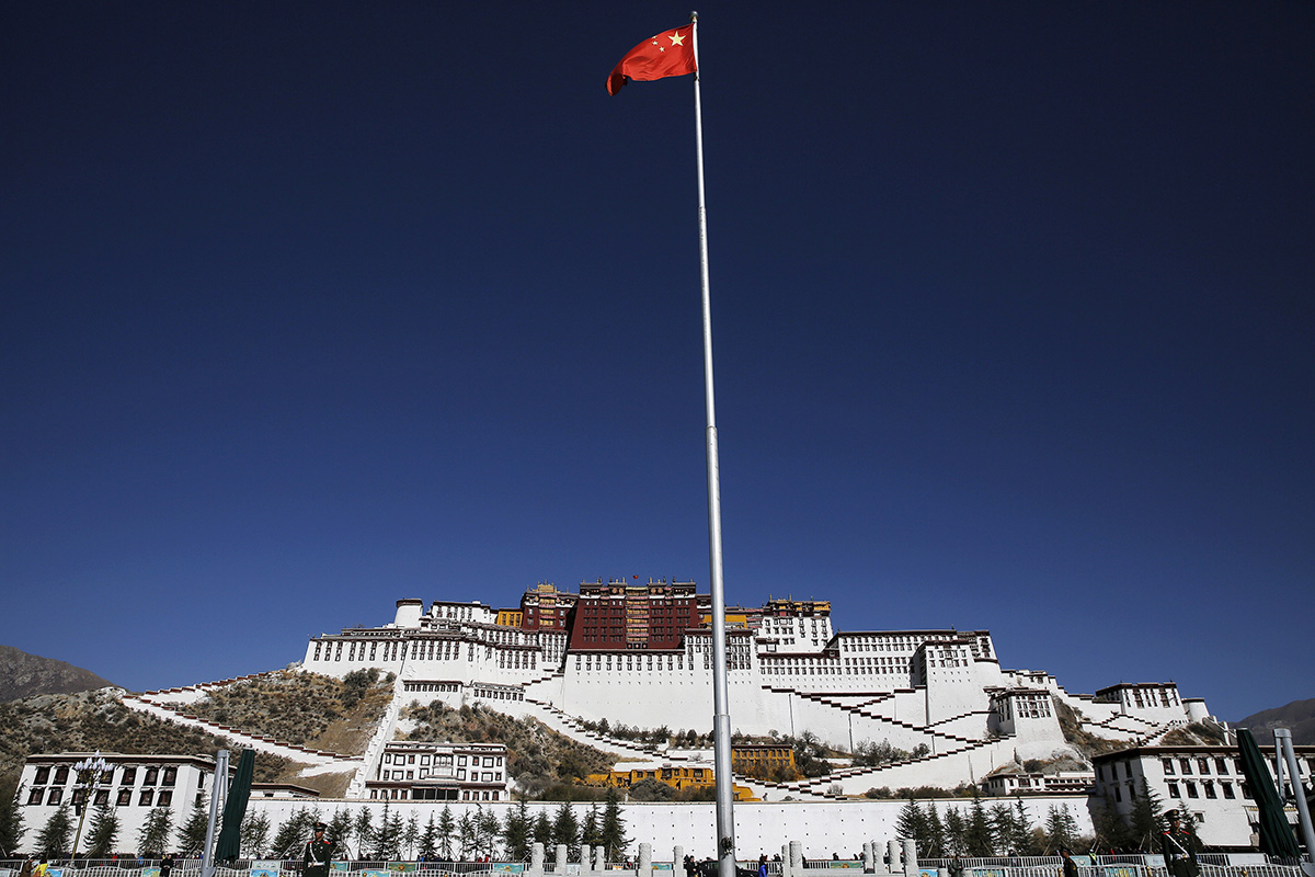 A Chinese flag flutters on a pole in front of the Potala Palace in Lhasa, Tibet Autonomous Region, China, on 17 November 2015.