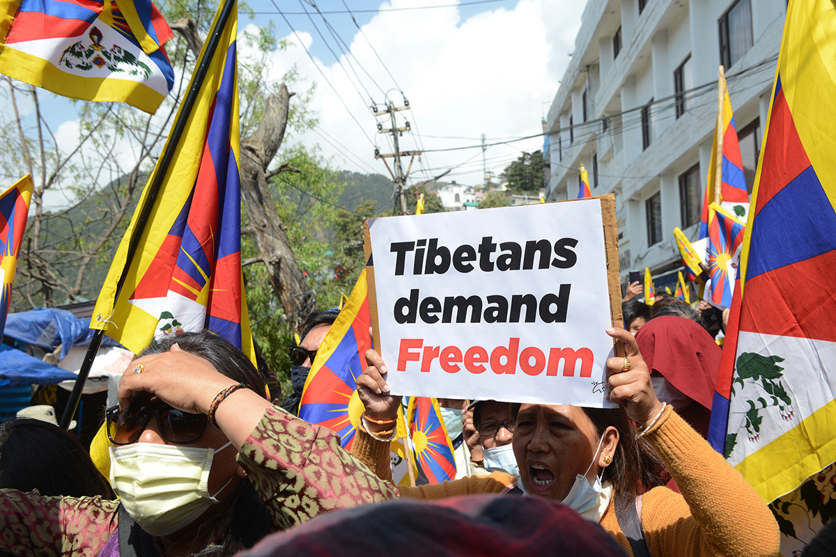 An exile Tibetan woman holds a placard as she shouts slogans during a demonstration marking the 62nd anniversary of the Tibetan uprising against the Chinese invasion of Tibet, in McLeod Ganj, India, on 10 March 2021. 