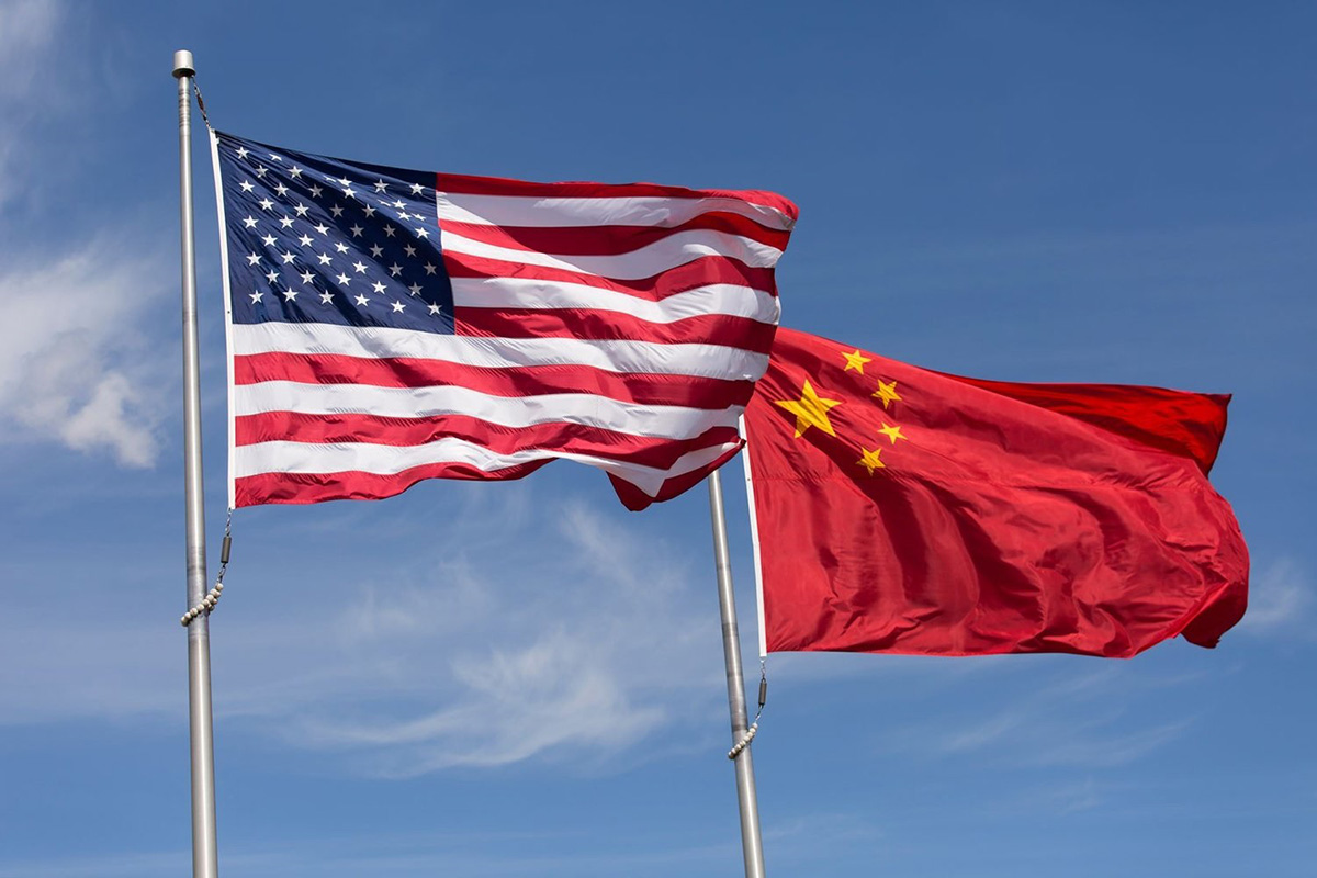 The flag of the United States of America and the flag of the People's Republic of China fly next to each other.