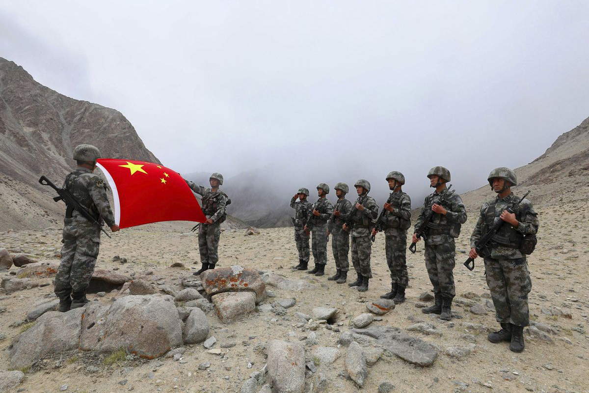 People's Liberation Army soldiers unfurl a Chinese national flag during a patrol on a border mountain on the Pamir Plateau in Kashgar in northwestern China's Xinjiang Uygur Autonomous Region on 6 September 2020.