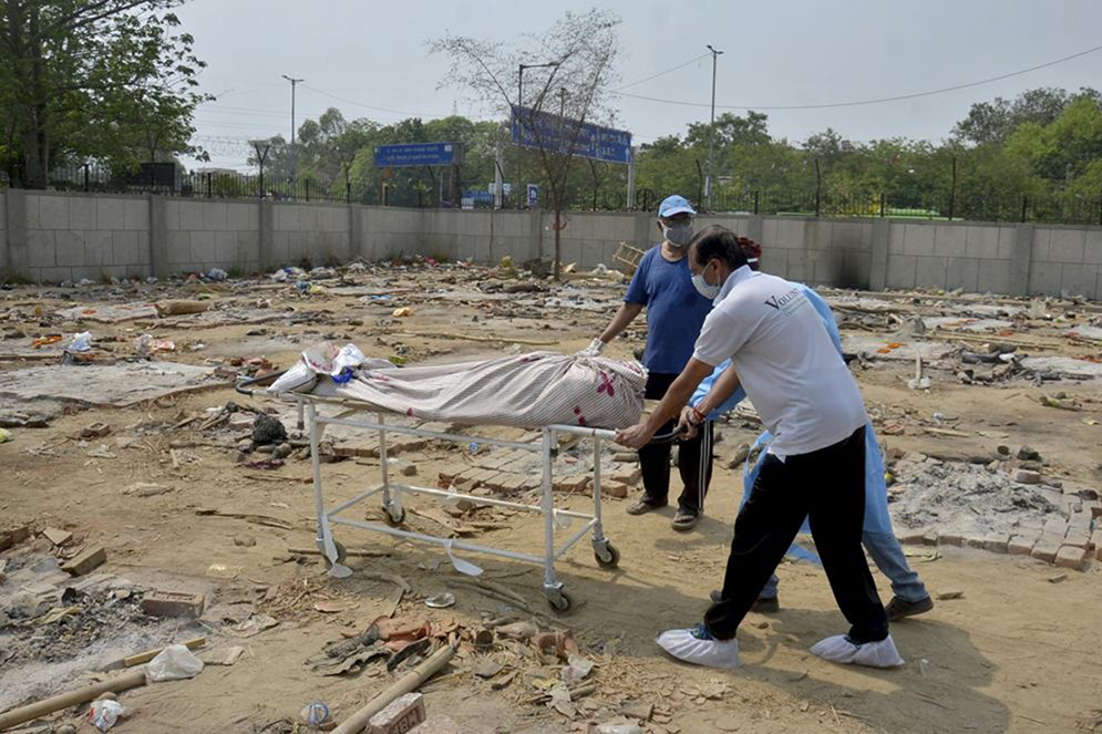 Body of a COVID-19 victim is wheeled in a ground that has been converted into a crematorium in New Delhi, India, on 1 May 2021. India on Saturday set yet another daily global record with 401,993 new cases, taking its tally to more than 19.1 million. Another 3,523 people died in the past 24 hours, raising the overall fatalities to 211,853, according to the Health Ministry. Experts believe both figures are an undercount.