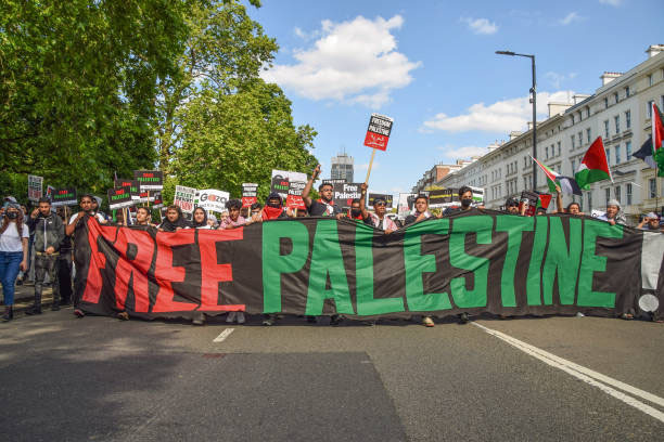 Protesters march with placards and a banner in Knightsbridge during the Justice For Palestine protest in London, United Kingdom, on 12 June 2021. Thousands of people marched through London to demand justice for Palestine and called on the G7 to end military cooperation with, and impose sanctions on, Israel.