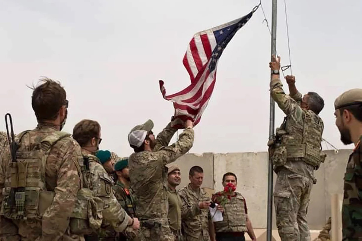 A US flag is lowered as American and Afghan soldiers attend a handover ceremony from the US Army to the Afghan National Army, at Camp Anthonic, in Helmand province, southern Afghanistan, on 2 May 2021.