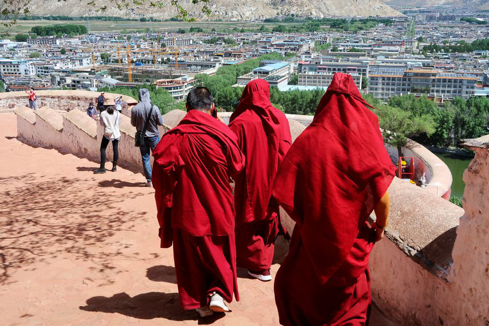 Tibetan Buddhist monks walk on the grounds of the Potala Palace overlooking the city of Lhasa, during a government-organised media tour to Tibet Autonomous Region, China, on 1 June 2021.
