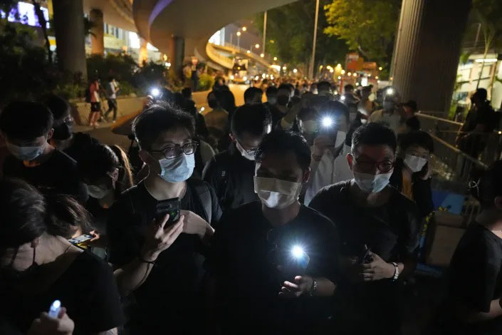 In this 4 June 2021 file photo, people hold LED candles to mark the anniversary of the military crackdown on a pro-democracy student movement in Beijing, outside Victoria Park in Hong Kong. The Hong Kong Alliance in Support of Patriotic Democratic Movements of China, one of Hong Kong’s most established pro-democracy civic organizations said Saturday, July 10, it is letting go its paid staff and halving the size of its steering committee amid Beijing’s crackdown on opposition activity in the semi-autonomous Chinese city.