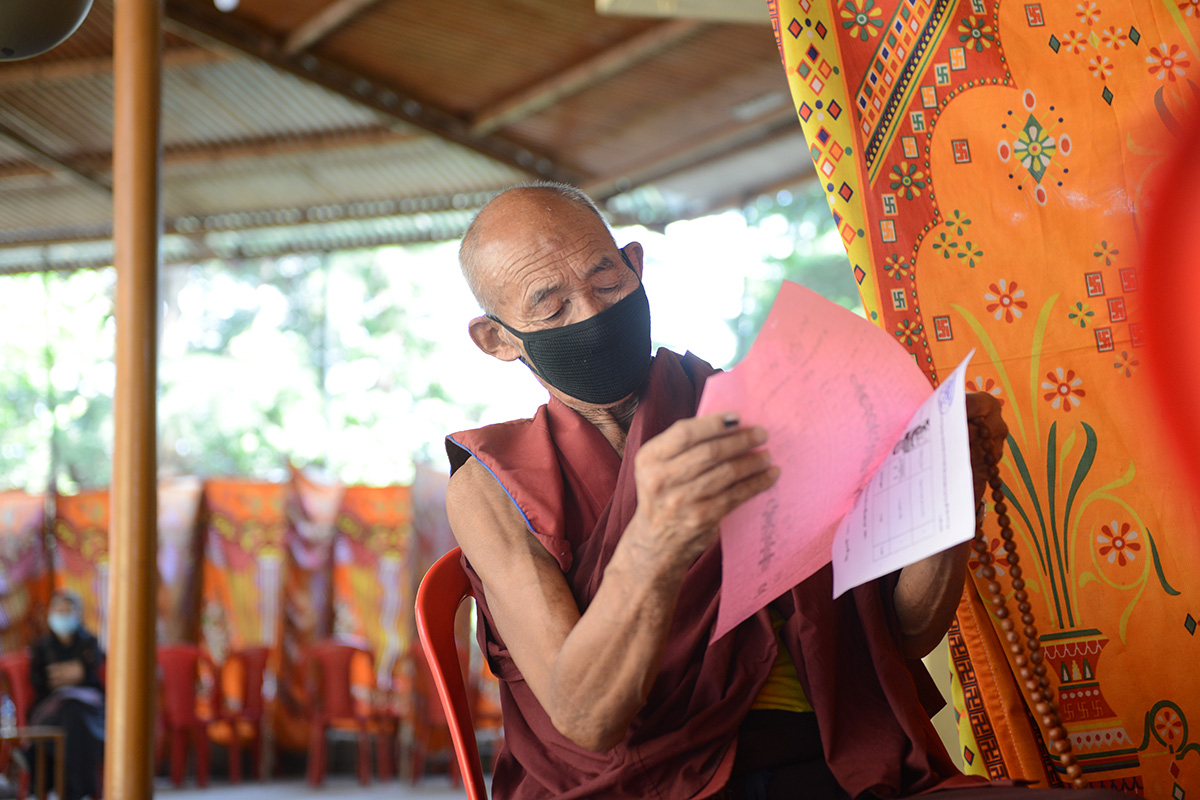 An elderly exile Tibetan monk reads the names on the ballot paper to choose his candidates for Sikyong and members of Parliament at a polling station in McLeod Ganj, India, on 11 April 2021.